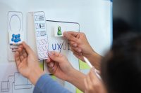 Close up ux developer and ui designer use augmented reality brainstorming about mobile app interface wireframe design on desk at modern office. creative digital development agency.